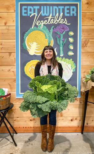 Lane Selman at the winter vegetable sagra holding a head of cabbage